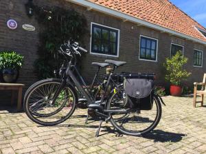 una bicicleta está estacionada frente a una casa en Bed and breakfast Zathe De Spieker, en Itens