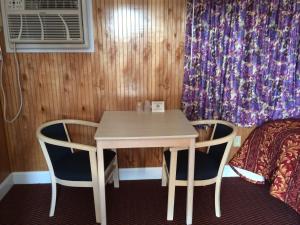 a room with a table and two chairs and a bed at Simpsons Motel in Rio Grande