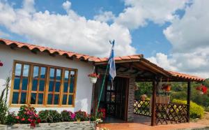 a house with a flag in front of it at Cabañas San Miguel Arcángel in San Gil