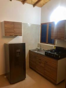 a kitchen with a black refrigerator and a sink at Cabañas San Miguel Arcángel in San Gil