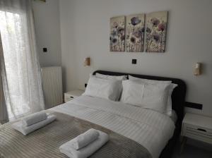 1 dormitorio con 1 cama con 2 toallas en Polyxenia’s Πλησίον Υγεία - Μητέρα - Ιασώ - ΟΑΚΑ, en Atenas