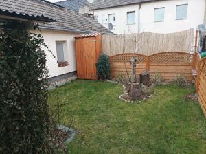 a backyard with a wooden fence and a yard at Fewo Luckenwalde zentral in Luckenwalde