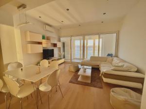 a living room with a couch and a table and chairs at First row to the sea - Nautilus Deluxe Apartment in Opatija