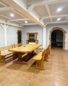a large wooden table in a room with benches at Hotel and Entertaiment Complex Vlada in Cherkasy