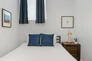 a bedroom with a bed with blue pillows and a window at 1BR Perfect Home in the City, Close to Everything - Lake 205 in Chicago