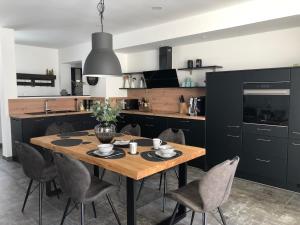 a kitchen with a wooden table and chairs at Zur alten Fabrik in Steinach