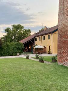 ein Haus mit einem Rasenplatz und einem Backsteingebäude in der Unterkunft La Fornace in Alessandria