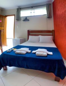 a bedroom with a bed with towels on it at Poupahotel Unidade Bairro in Taubaté