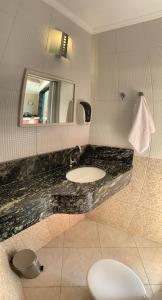 a bathroom with a sink and a mirror at Poupahotel Unidade Bairro in Taubaté +18 photos