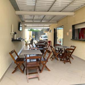 a group of tables and chairs on a patio at Poupahotel Unidade Bairro in Taubaté