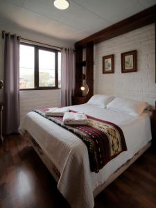 um quarto com uma cama grande e uma janela em Apartamentos Otorongo Cuenca Ecuador em Cuenca