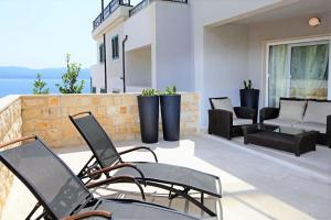 a patio with chairs and a couch on a balcony at Apartment Bol A6 with Pool from 45 EUR per Person in Bol
