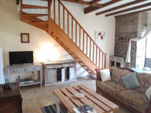 a living room with a couch and a staircase at Gîte La Grange in Langoëlan