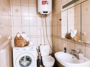 een badkamer met een wasmachine en een wastafel bij simsimdoba in Tsjernivsi