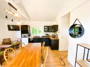 una cucina e una sala da pranzo con tavolo e sedie in legno di Atypique Chalet la rivière sous votre fenêtre a Plésidy Altre 11 foto