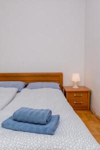 łóżko z niebieskim ręcznikiem na górze w obiekcie Rooms in the center w Gdańsku