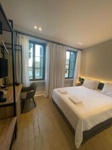 a bedroom with a bed and a desk and windows at Acron Athens in Athens