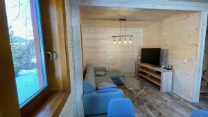 a living room with a blue couch and a tv at Chata na samote - Kráľova Lehota in Kráľová Lehota
