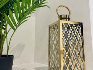 a gold lantern standing next to a plant at Stylish studio apartment in centre of St Clears in St Clears