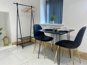 a dining room table with two chairs and a black table at Stylish studio apartment in centre of St Clears in St Clears