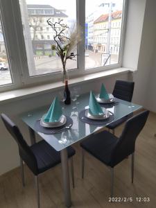 a dining room table with chairs and a table with a vase at Krásny byt s výhľadmi v historickom centre in Bratislava +11 photos