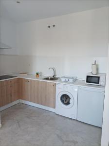 een keuken met een wasmachine en een wastafel bij IJD apartments 119 PARKING GRATIS Y PISCINA in Bormujos