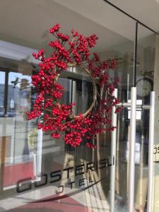 una corona con flores rojas en la ventana de una tienda en Gosterisli Otel, en Duzce