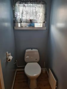 ein kleines Bad mit einem WC und einem Fenster in der Unterkunft Festningsgaten 3 b in Vardø