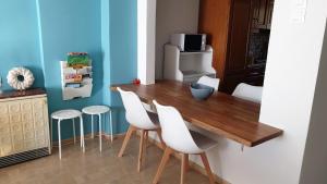 a kitchen with a wooden table and white chairs at Alma Maisonette in Kavála +28 photos