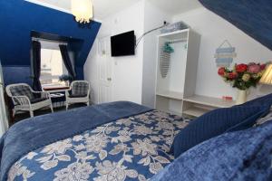 
a bedroom with a bed and a desk at Braeside Guest Rooms in Portree
