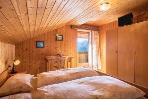 een slaapkamer met 2 bedden in een kamer met een raam bij Appartamento mansardato in San Martino in Badia