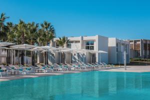 a swimming pool with chairs and umbrellas at Iberostar Waves Cala Domingos All Inclusive in Calas de Mallorca