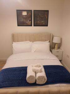 a bedroom with a bed with two towels on it at The Joyland House in Romsey
