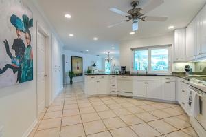 a large kitchen with white cabinets and a tile floor at Exclusive Villa - Lakeside, 4 Minutes to Private Beach in Naples
