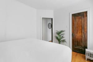 um quarto com uma cama branca e um espelho em Charming 1BR Apt in North Center Near Shops- Larchmont 3 em Chicago