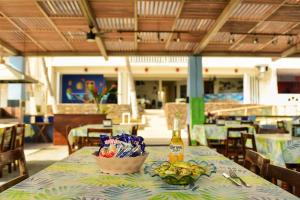 a table with a bottle of beer and a basket of fruit at Bungalows Las Hamacas in San Patricio Melaque