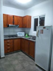 a kitchen with wooden cabinets and a refrigerator at Punta Cana Blue Beach Estudio in Punta Cana