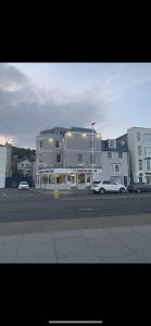 un gran edificio con coches estacionados en un estacionamiento en Master accommodation suite 2 sea view with balcony en Hastings