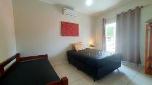 Un dormitorio pequeño con una cama y una ventana. en Piscina Aquecida, 5 suítes, Bilhar, Varanda Gourmet, 100mts mar, en Itanhaém 27 fotos más