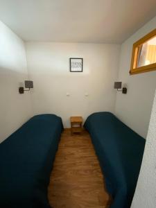 a bedroom with two beds and a small table at Residence la Dame Blanche 1800 in Puy-Saint-Vincent