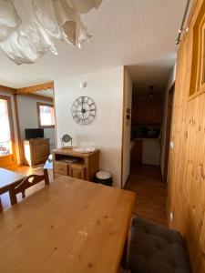 a kitchen and dining room with a table and a clock on the wall at Residence la Dame Blanche 1800 in Puy-Saint-Vincent