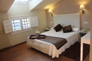 una camera d'albergo con un letto e due finestre di Hotel Leonor de Aquitania a Cuenca