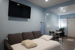 a living room with a couch and a flat screen tv at 24 Hours Motel in Los Angeles