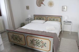 ein Bett in einem Zimmer mit zwei Nachttischen und zwei Tischen in der Unterkunft apartment vista monastero in Dubino