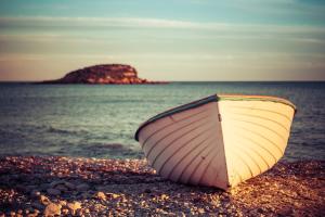 a boat sitting on a beach near the water at Gran H La Marina in Altea