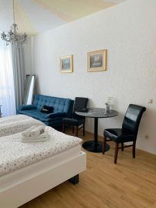 una camera con letto, tavolo e sedie di Nathalie Leser a Baden-Baden