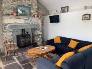a living room with a blue couch and a fireplace at Pen Y Braich Uchaf in Brynkir