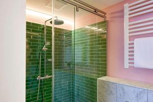 a bathroom with green subway tiles and a shower at Central Hotel Münster in Münster