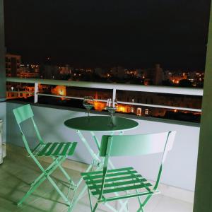 una mesa y sillas en un balcón con vistas en Lunas de Salta depto, cochera, balcón a 600m plaza principal en Salta