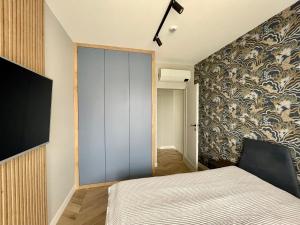 a bedroom with a sliding glass door leading to a bed at Rezydencja Niechorze Off Shore Go in Niechorze